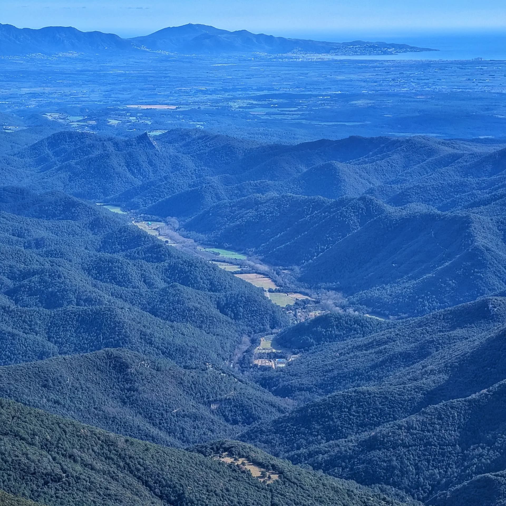View from Bassegoda summit with Albanyà Valley in the foreground, the sea, and Cap de Creus in the background.