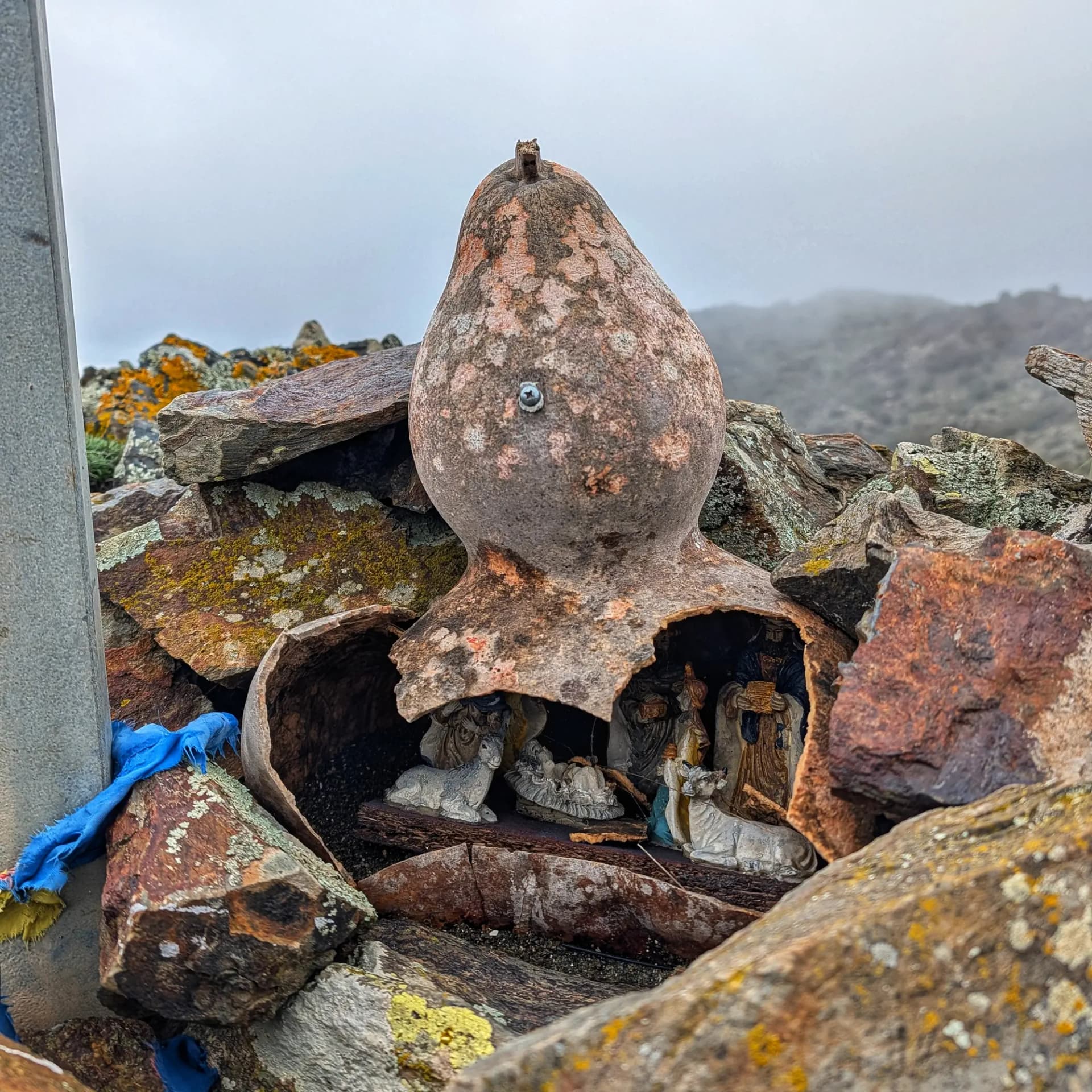 Belen dentro de una calabaza envejecida entre rocas en una cumbre montañosa.