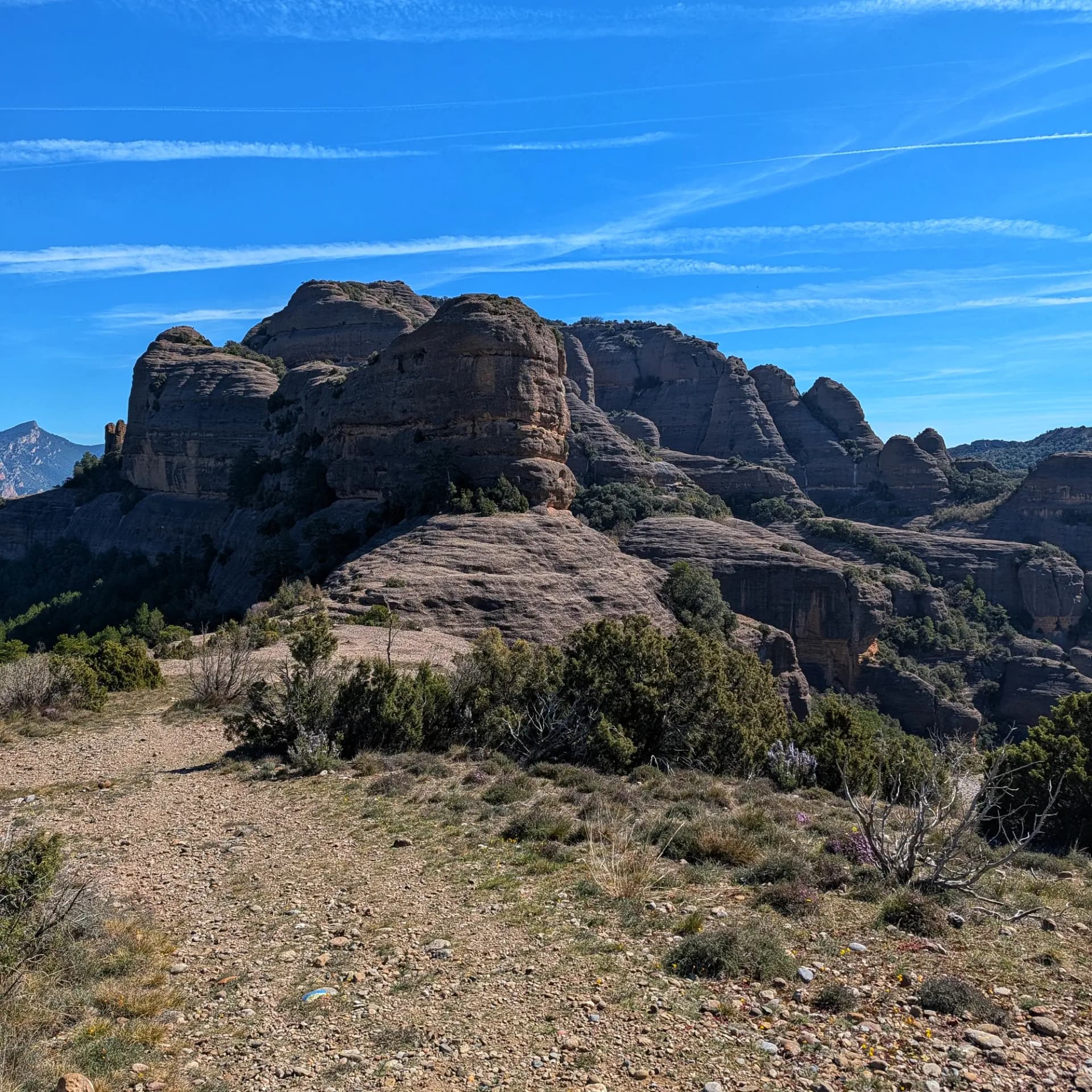 Vistes de formacions rocoses de conglomerat a Sant Honorat des del Coll de Mu sota cel blau amb esteles.