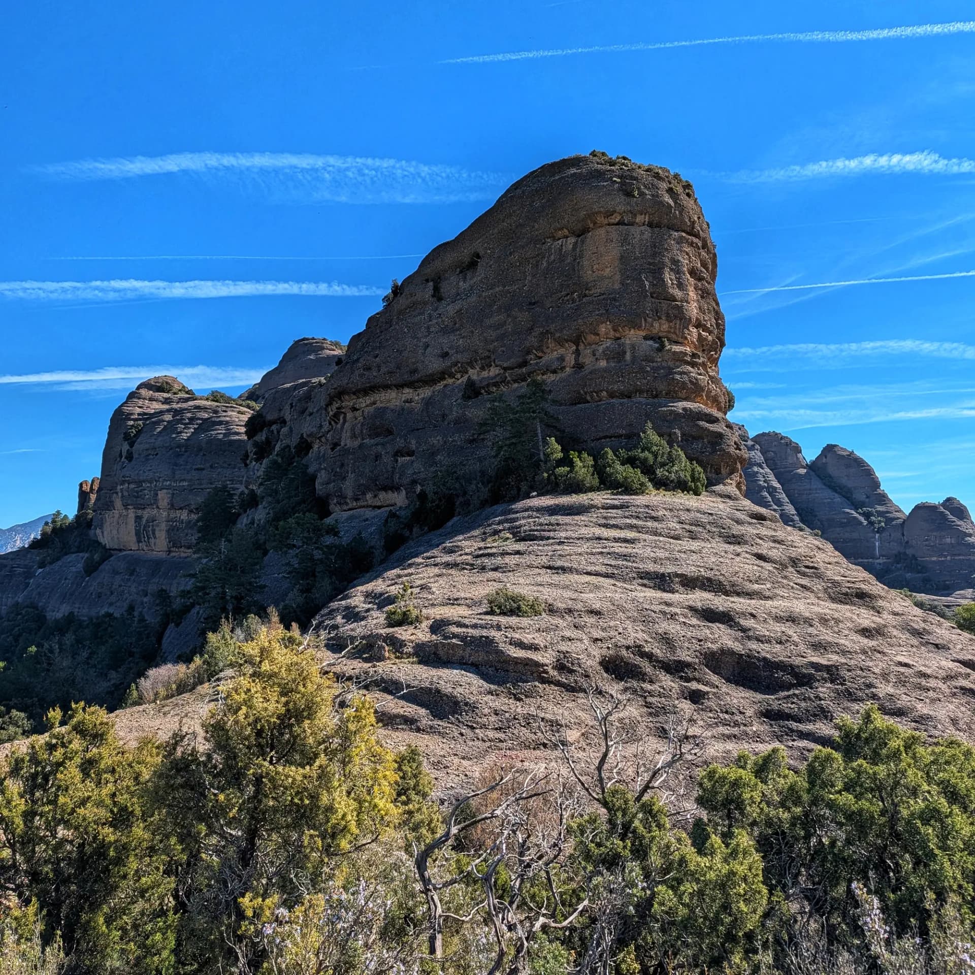 Formació rocosa de conglomerat a Sant Honorat, vista des de Coll de Mu, sota cel blau amb esteles.
