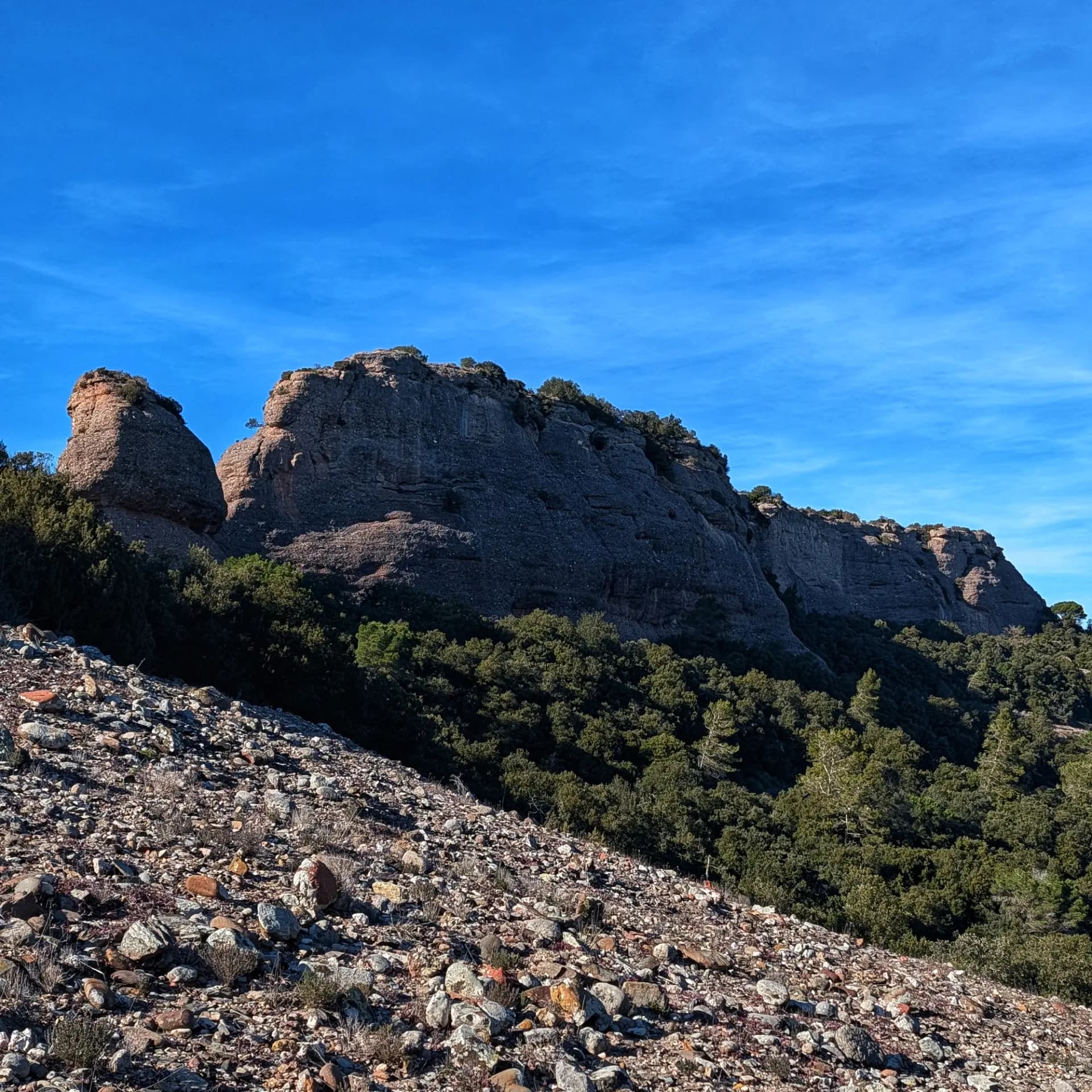 Castellsapera: imponents formacions rocoses, bosc dens i tartera sota un cel blau al Parc Natural de Sant Llorenç del Munt i l'Obac.