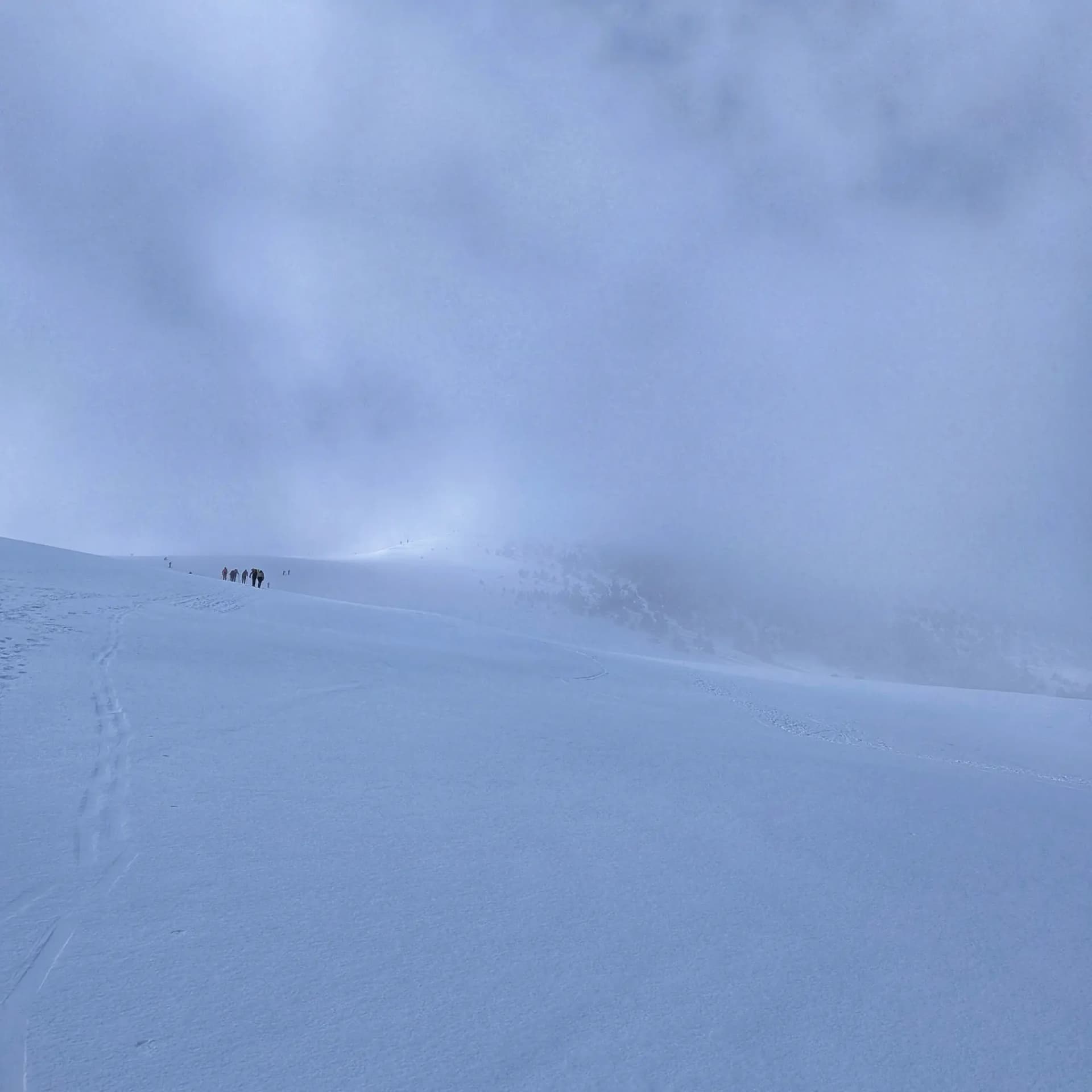 Paisatge nevat i boirós al Taga amb petits grups de gent pujant pel camí.