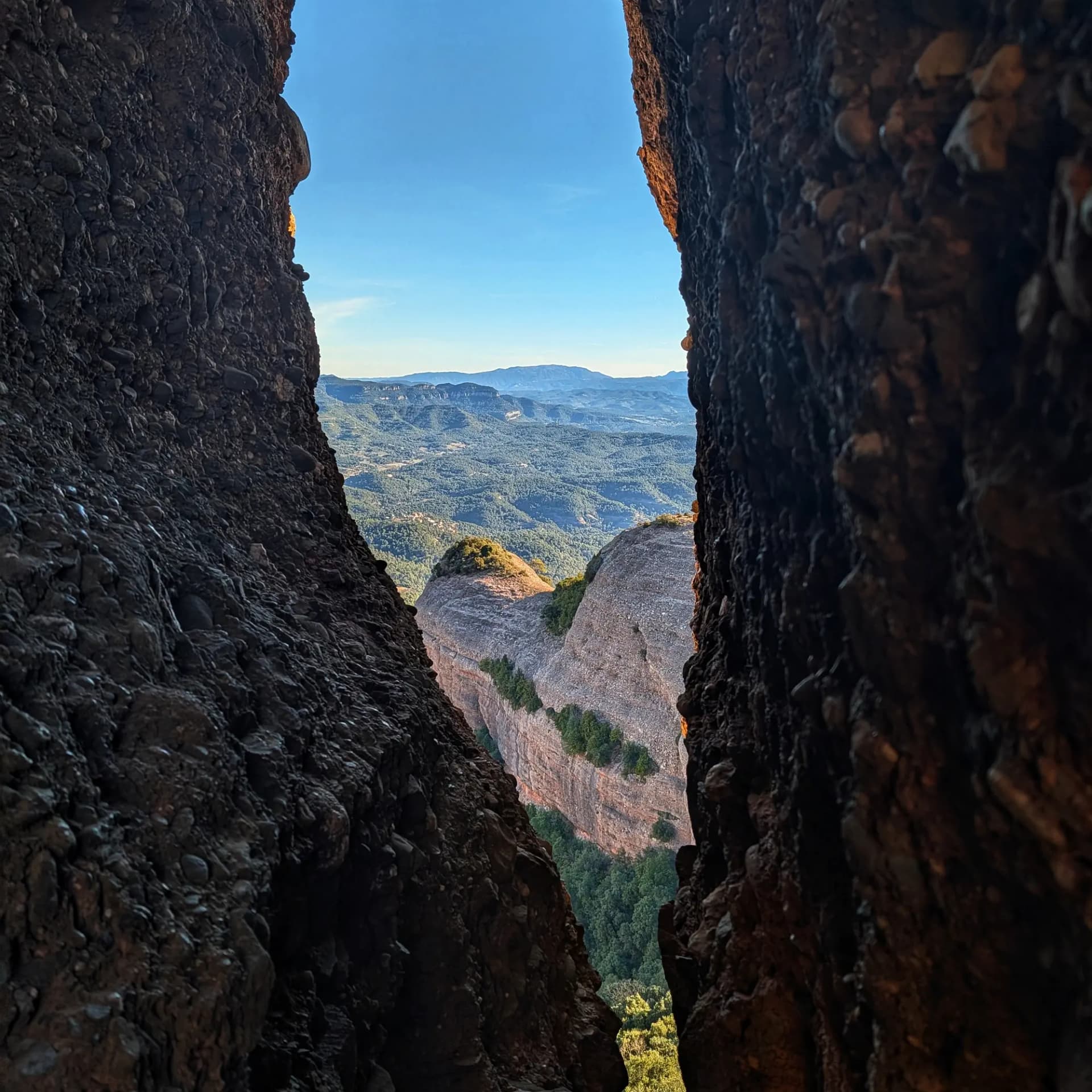 Vista panoràmica del Parc Natural de Sant Llorenç del Munt i l'Obac emmarcada per les roques del Morral del Drac.