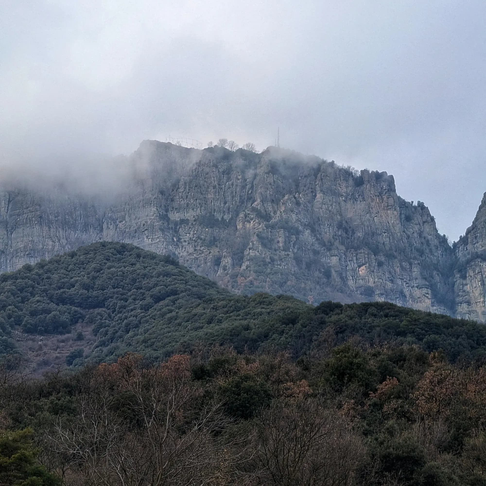 Panoràmica de Puig Cornelis amb l'estrella de Nadal i antenes emergint de la boira, des de Joanetes.