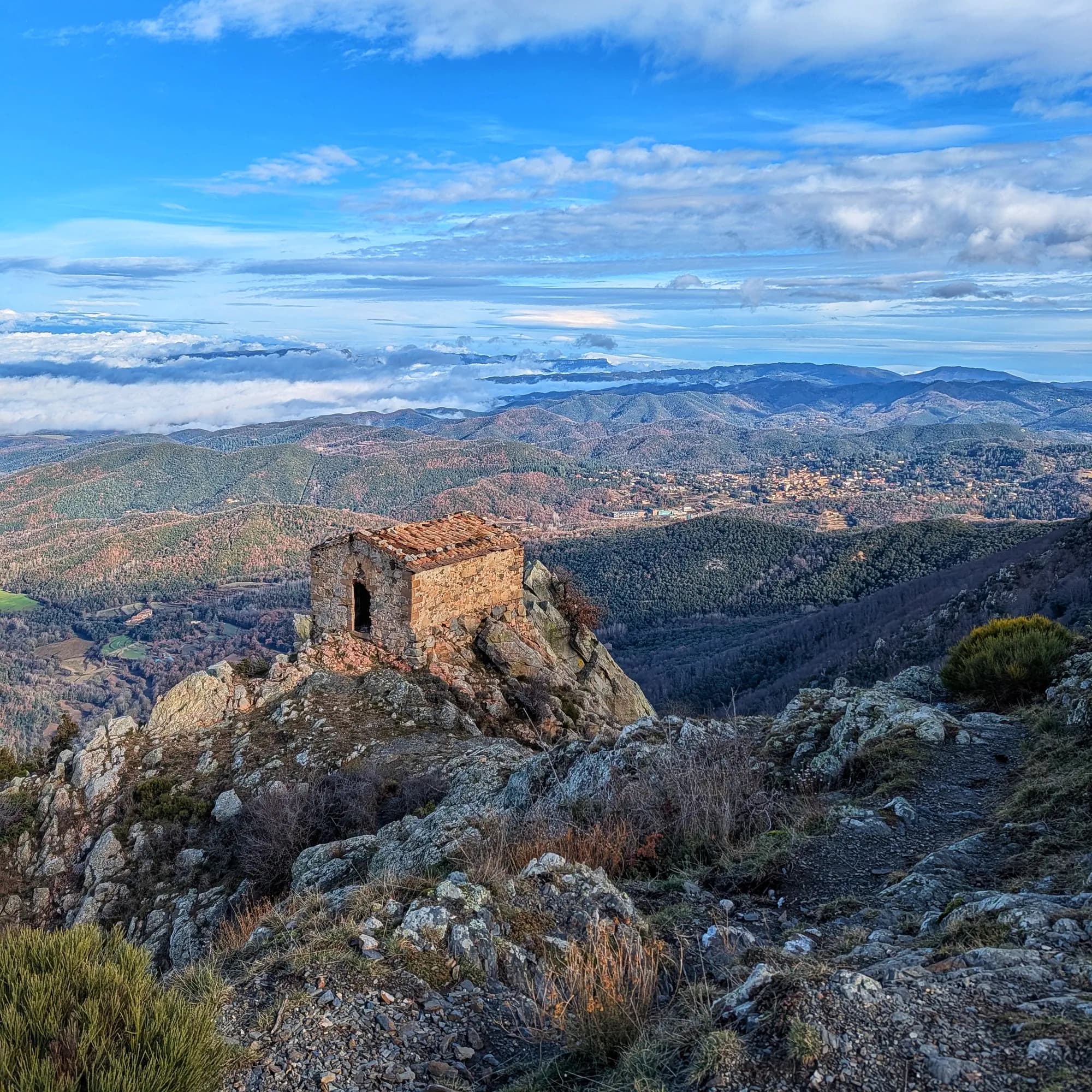 Ermita de Sant Miquel de Barretons en un roquissar a 1300m, amb el Far al fons.
