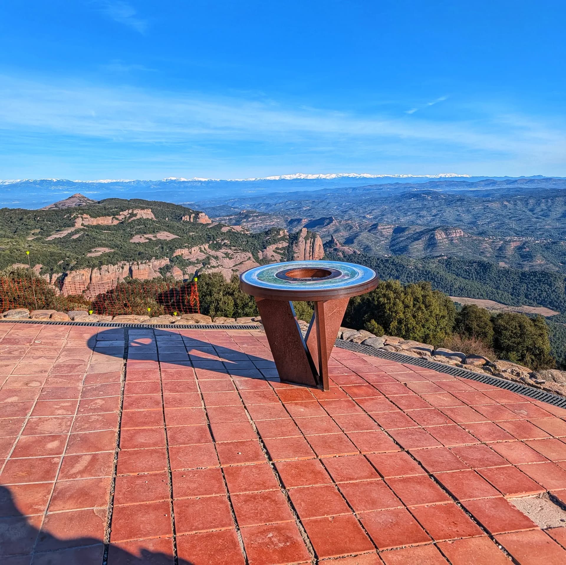 Vistes panoràmiques des del cim de La Mola de Sant Llorenç, al Parc Natural de Sant Llorenç del Munt i l'Obac. La taula interpretativa senyala els pics circumdants com el Montcau i el Turó de la Pola, amb la serralada dels Pirineus nevats al fons. La Mola, Sant Llorenç del Munt i l'Obac. Taula interpretativa amb vista panoràmica a muntanyes nevades.