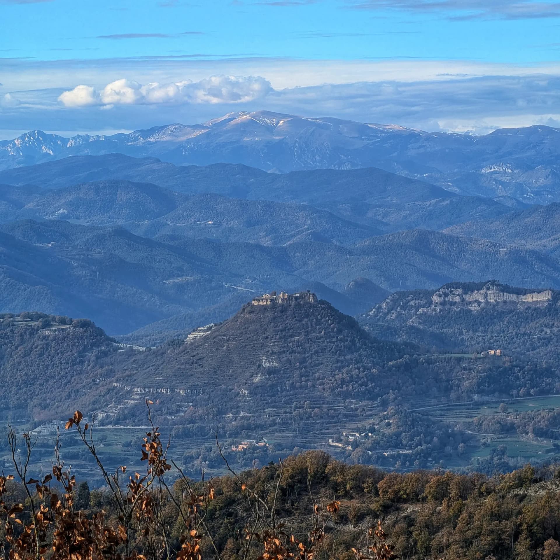 From Bellmunt summit: Besora Castle stands prominently in the center of the image, with the imposing Penyes Altes del Moixeró visible in the background on the left. In the central background, La Molina can be seen, flanked by Tosa d'Alp on the left and Puigllançada on the right. Besora Castle, Penyes Altes del Moixeró and La Molina (Tosa d'Alp and Puigllançada peaks) from Bellmunt peak