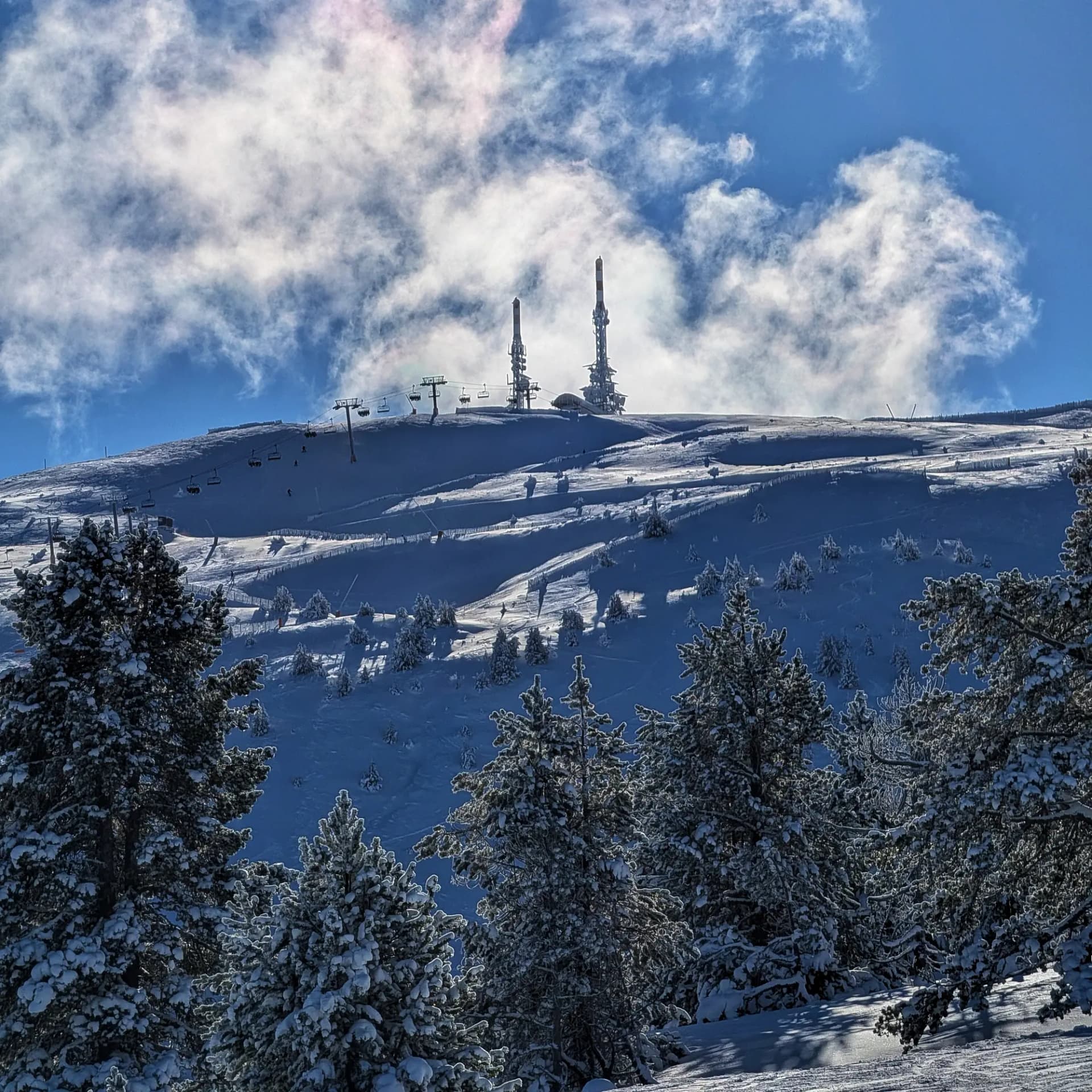 La Torreta de l'Orri, un cim de muntanya, fotografiada des de les pistes durant un ascens. La imatge mostra la muntanya nevada en un entorn alpí. Torreta de l'Orri, cim de muntanya amb neu, vist des de les pistes d'ascens. Paisatge alpí.