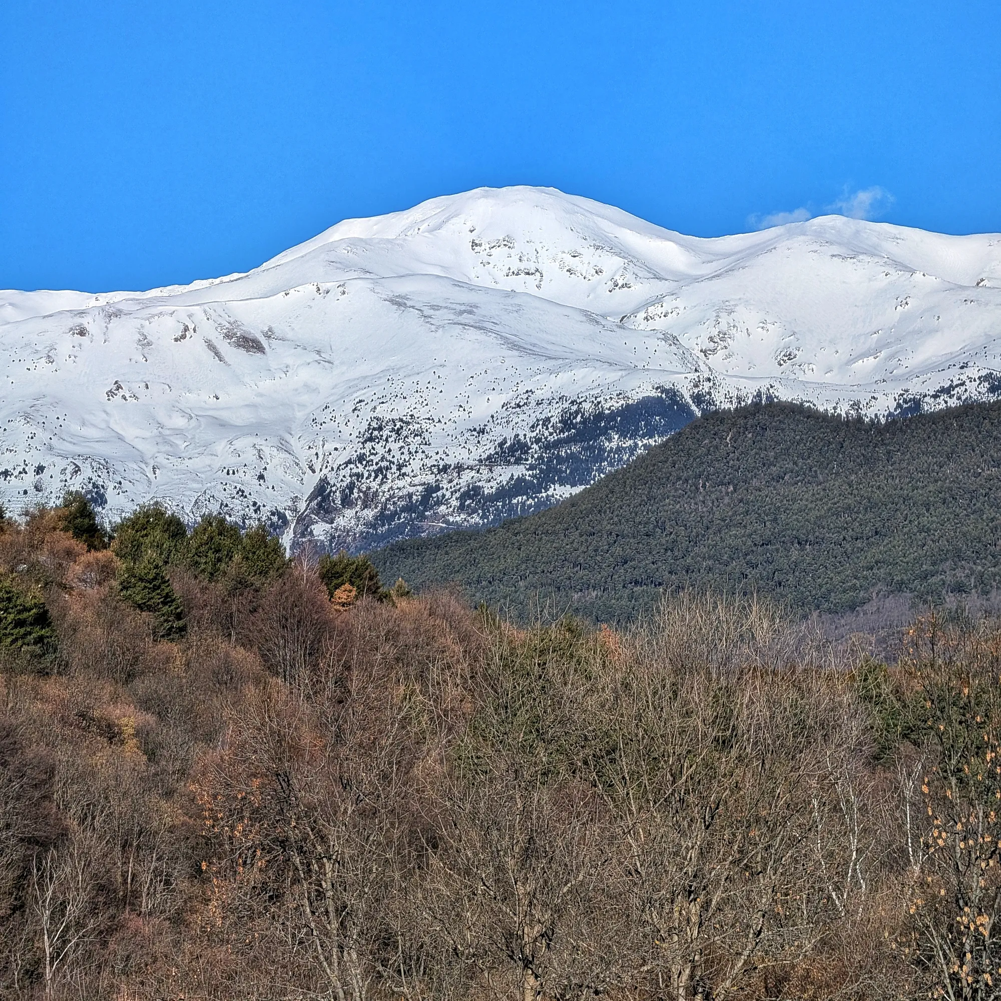 Panoràmica del Puigmal nevat, capturada des de la ruta d'ascens cap al Taga. Un paisatge hivernal imponent als Pirineus catalans. Panoràmica del Puigmal nevat des d'una ruta d'ascens al Taga, amb cel clar.